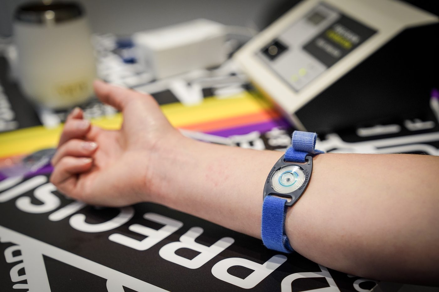 Sweat collector strapped to an athlete's forearm during a sweat test, in front of the analyser.